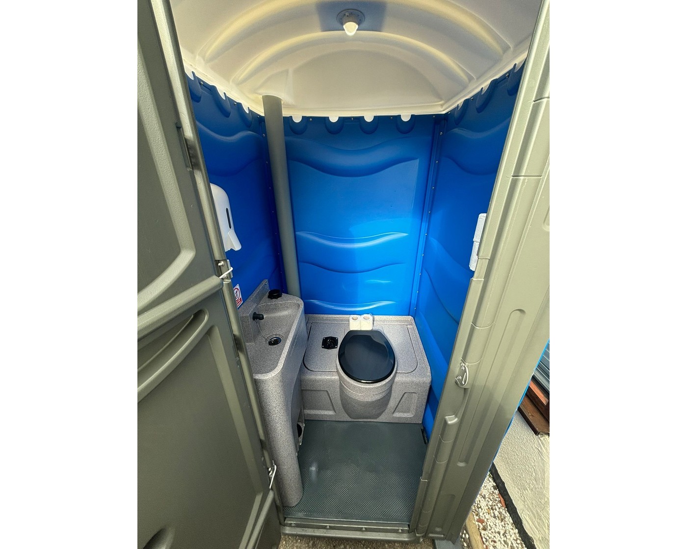Inside an HSE-compliant portable toilet with foot-operated wash basin