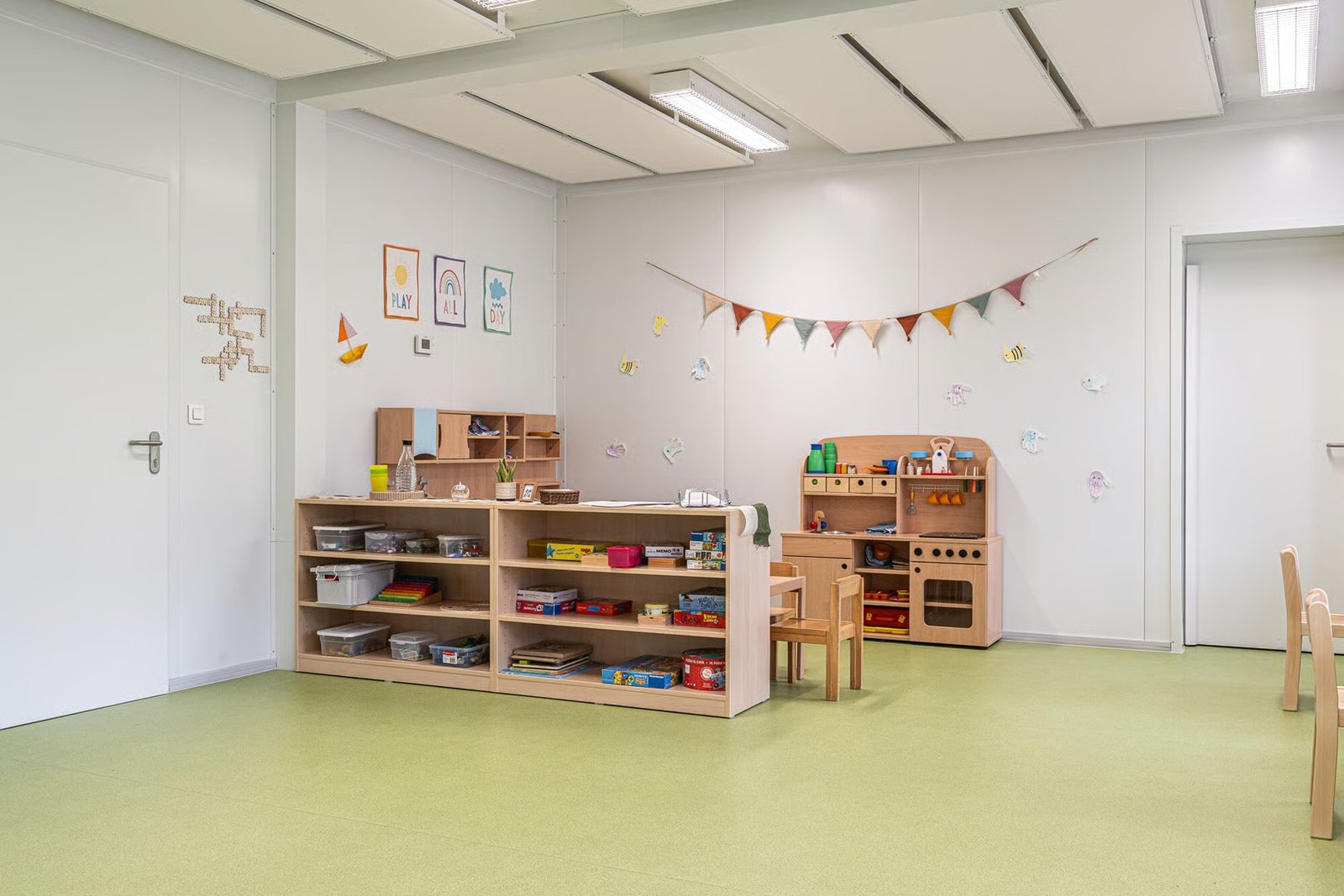 nursery room with toy shelving and soft green floor