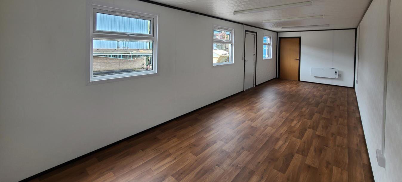 open plan jackleg cabin interior with wood floor and rooms off