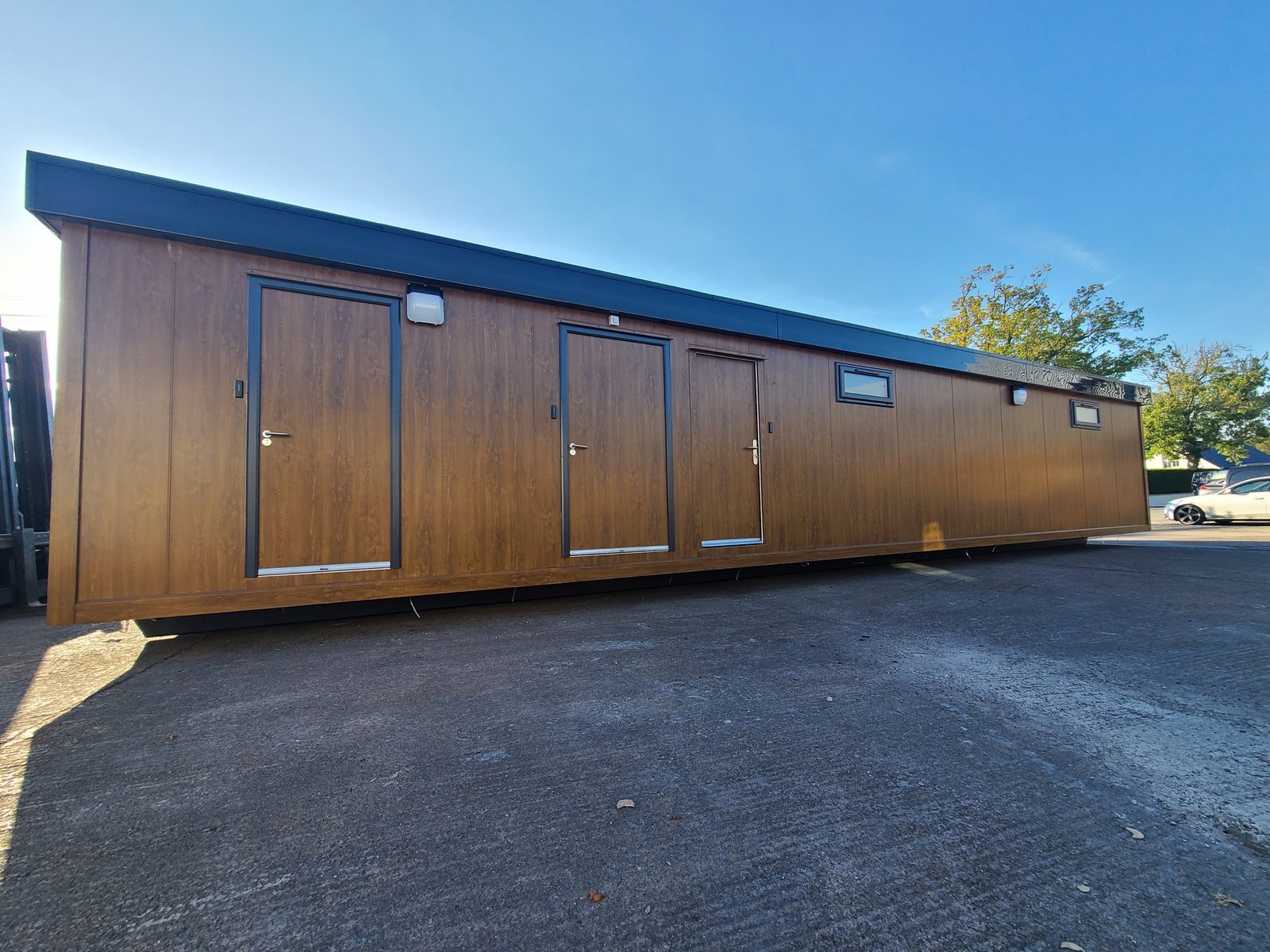 timber clad luxury toilet and shower block exterior with three entrance doors