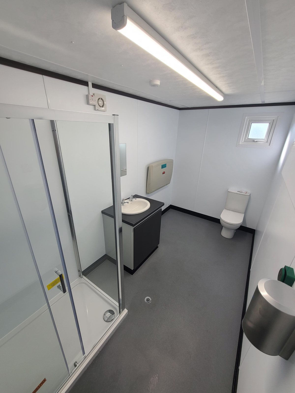 wet room with shower enclosure, basin and WC in a modular shower block